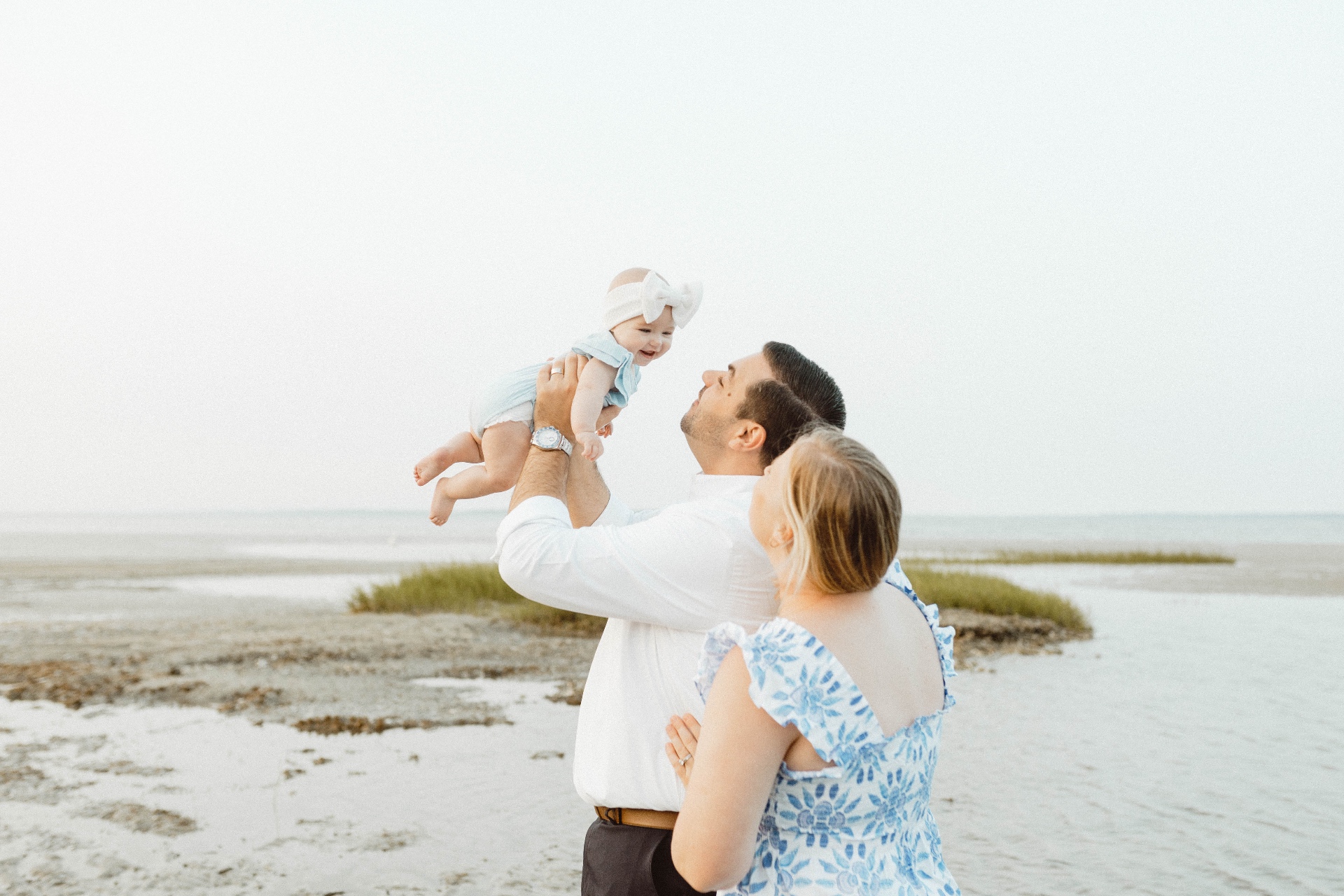 Happy family with baby enjoying a sunny day at the beach